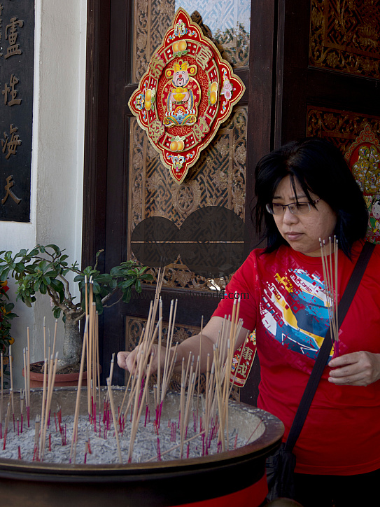 Woman paying respect at a temple on the eve of Chinese New Year in Singapore