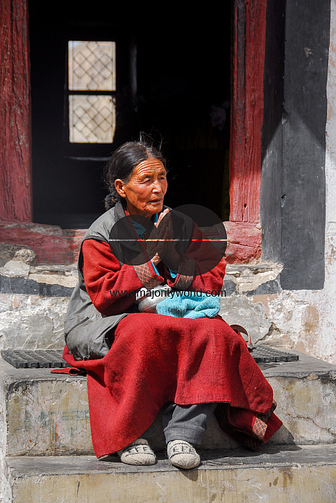 A woman praying outside in the Thiksey Monastery, Ladakh.