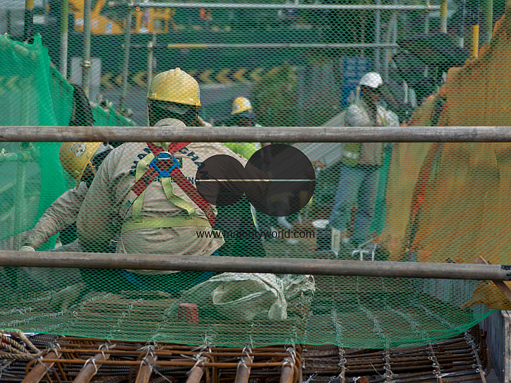 Migrant workers at a construction site by a highway in Singapore