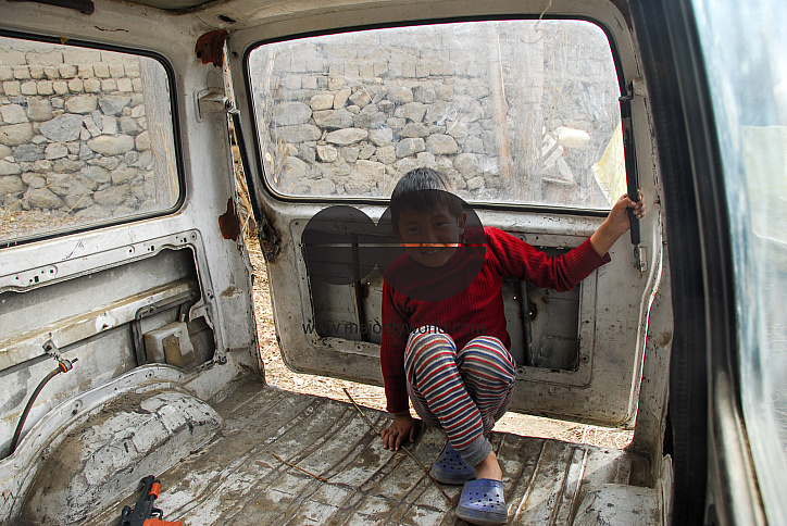 A boy playing inside an old Maruti Van parked in a backyard in Leh, Ladakh.