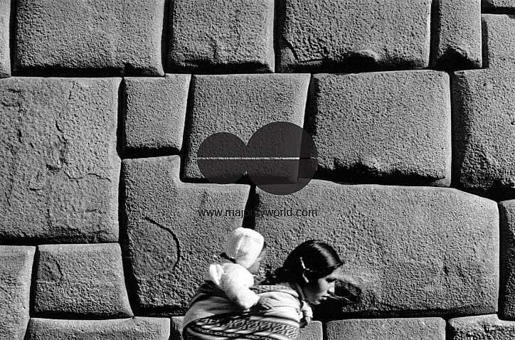PERU NATIVE QUECHUA WOMAN AND CHILD WALK PAST THE INCA STONES IN CUZCO, 1992