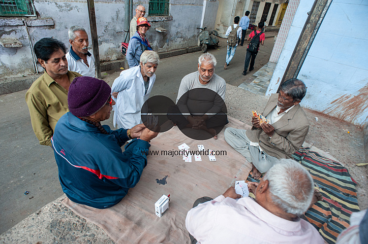  Elderly local men play cards in the bylanes of Jodhpur as tourists and other locals watch.