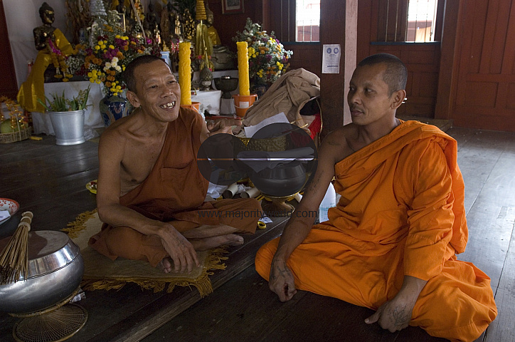 Thailand. Monks seated at their temple in Samut Songkhram.