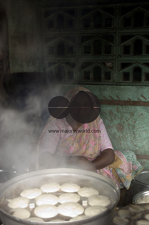 India. Woman cooking Iddly in South India.