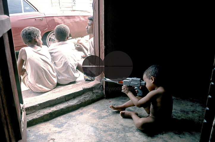 DOMINICAN REPUBLIC CHILD PLAYING WITH TOY MACHINE GUN IN THE OUTSKIRTS OF SANTO DOMINGO. Photo ¬© Julio Etchart