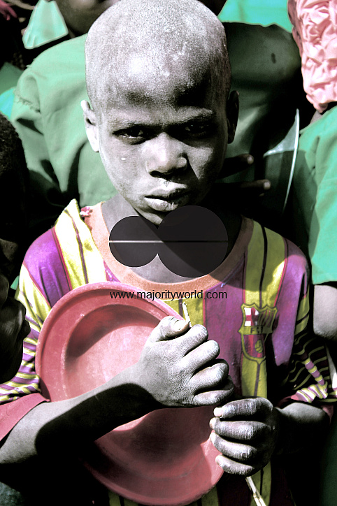 A returnee boy waits for food at Lassa town during a school Christmas party. The party attracted man