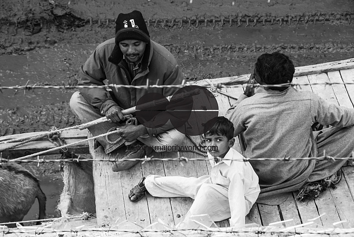  People sit on a cart pulled by a donkey, Lahore.
