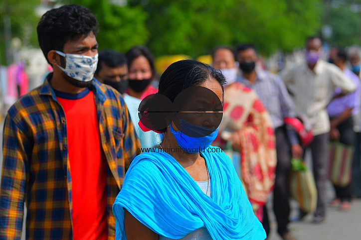 People are standing in a line, to check their temperatures