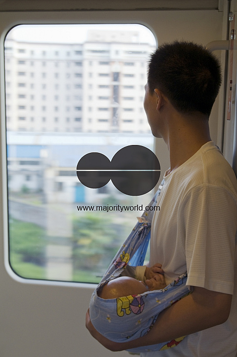CHINA Migrant workers from the countryside returning home with baby by train from Guangzhou, Guangdong province.