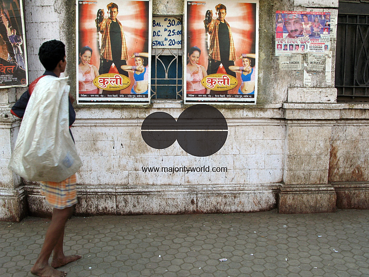 INDIA.People walking past an old picture house in Mumbai.