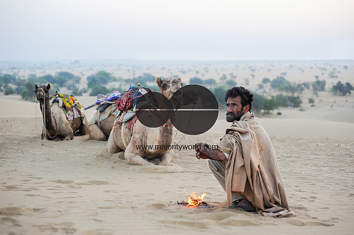  A camel herder warms his hands mid-safari on a winter morning, Jaisalmer.