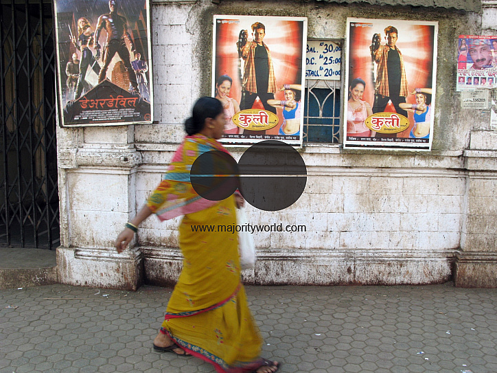 INDIA.People walking past an old picture house in Mumbai.