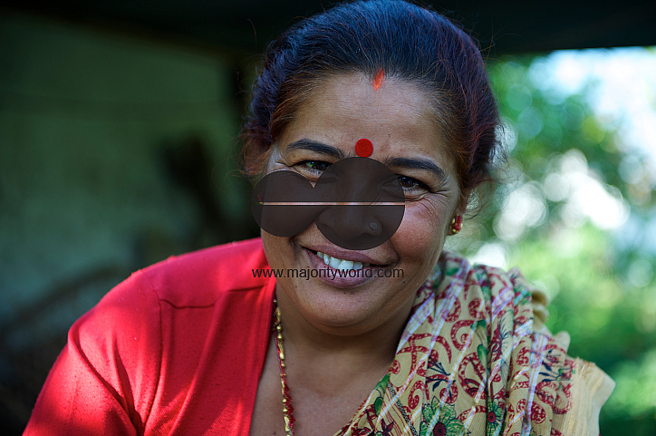  A female community health volunteer, stands outside her home