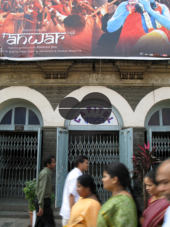 INDIA.People walking past an old picture house in Mumbai.