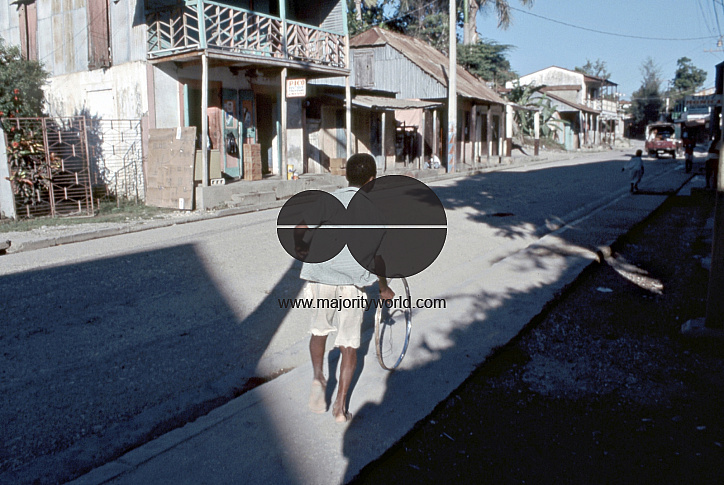 HAITI YOUTH PLAYING WITH A WHEEL IN THE STREETS OF JACMEL. Photo ¬© Julio Etchart