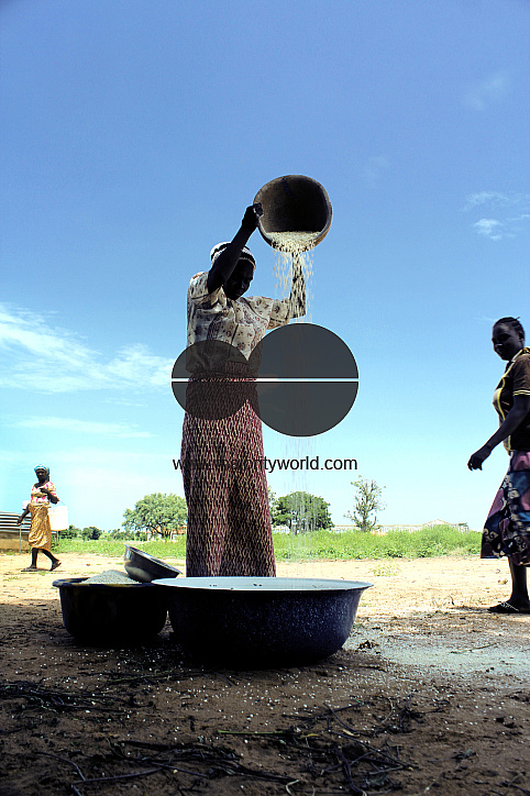 An IDP woman uses a local method to blow-out husks from beans, which is to be sold in market the nex