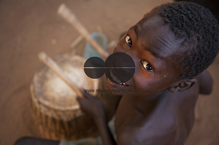  A young boy plays drum during a community dance