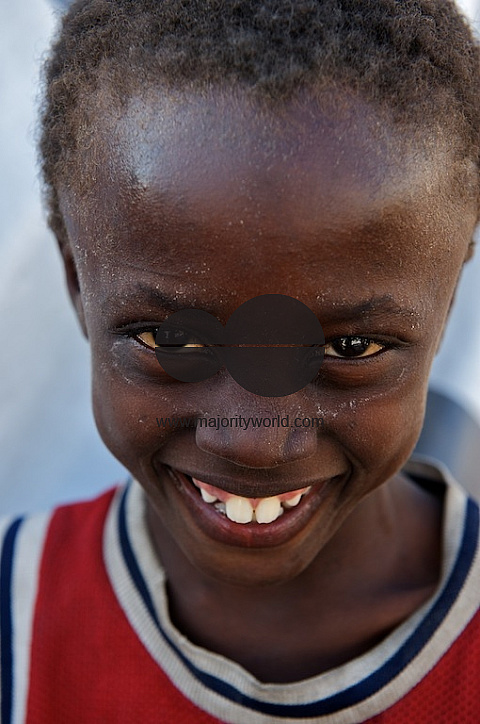 Young Haiti boy smiles at camera.