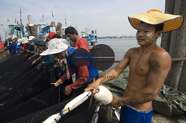 Thailand. Burmese fisherman working beside river at Samut Songkran.