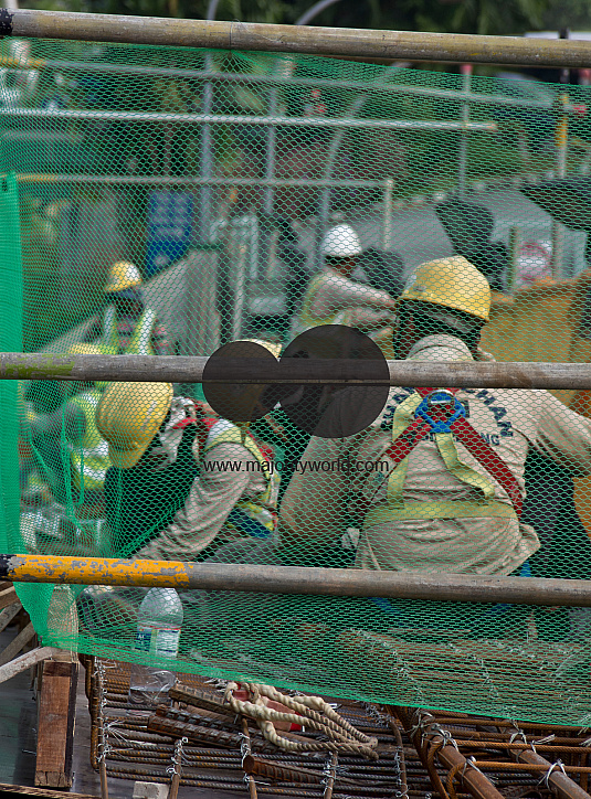Migrant workers at a construction site by a highway in Singapore