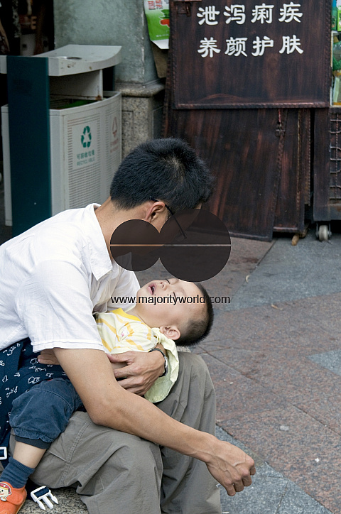 CHINA father with sleeping son in Guangzhou, Guangdong province..