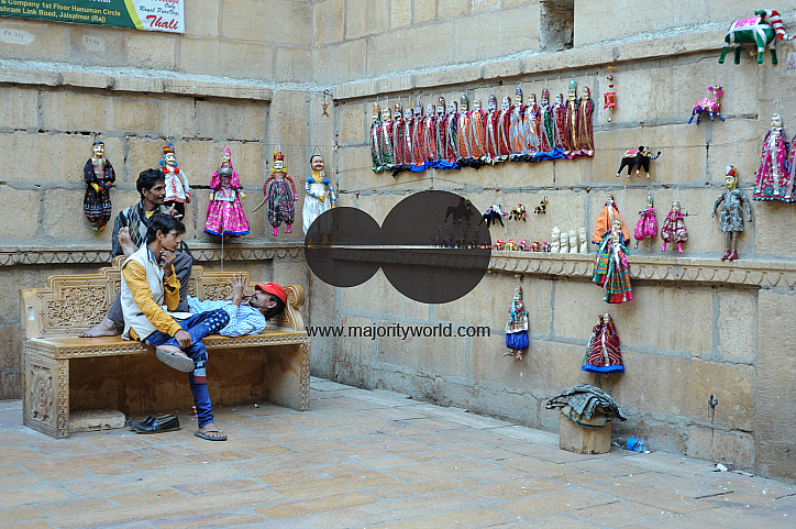  Locals look at traditional looking dolls that are for sale on the street side in Jaisalmer.