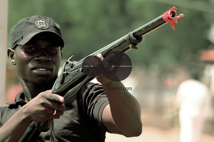 A member of Banga poses with a local gun, which is used within the city of Jimeta-Yola. The red clot