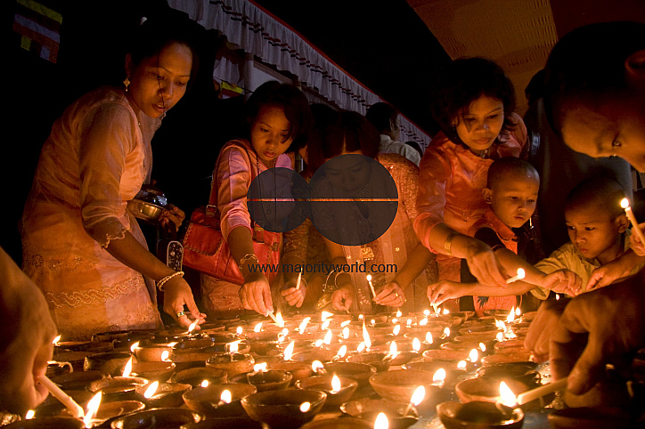 Buddhists celebrating Prabarana Purnima with lighing lamps