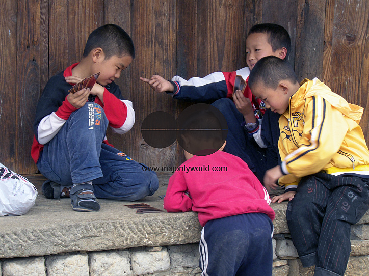 CHINA Children playing cards in a village in Yunnan province.