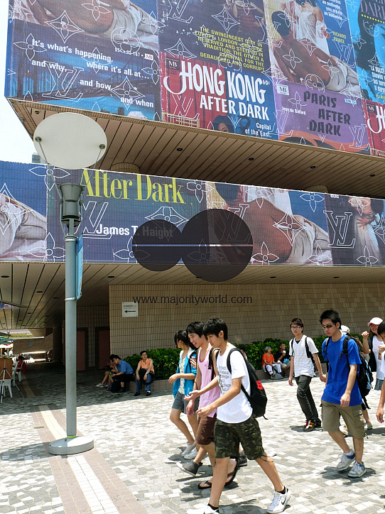CHINA Students walking past advertising billboards in Hong Kong.