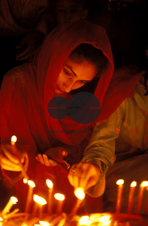 A woman lights candles on the occasion of Budha Purnima