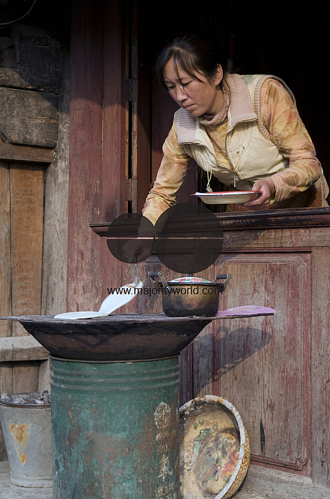 CHINA Vendor selling flat bread at the market place in a village in Yunnan province.