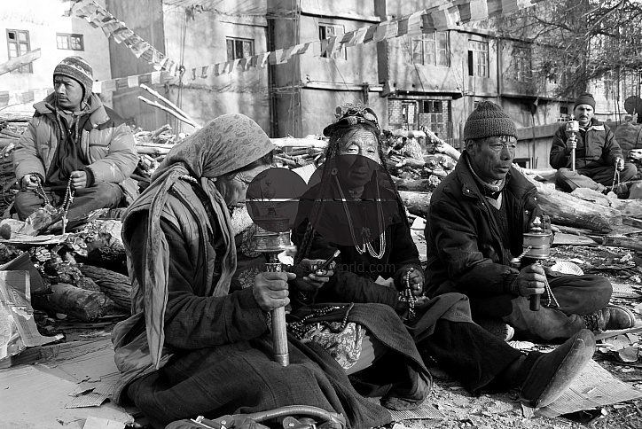 Men and women sitting near a Temple with prayer wheels and beads in Leh, Ladakh.