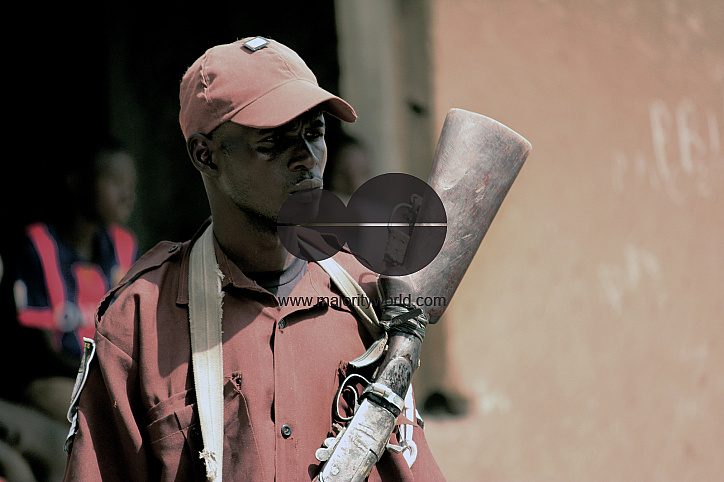 A member of Lassa vigilante acts as a guard in a school organized for returnee displaced persons.