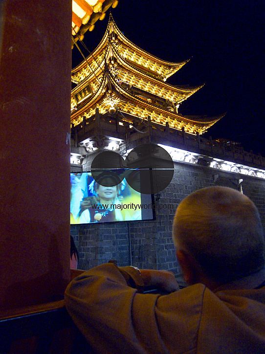 CHINA Elderly man watching a movie at an outdoor screen in Dali, Yunnan province.