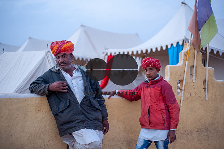  Musicians who perform for tourists in the desert wait outside the premises at dusk.