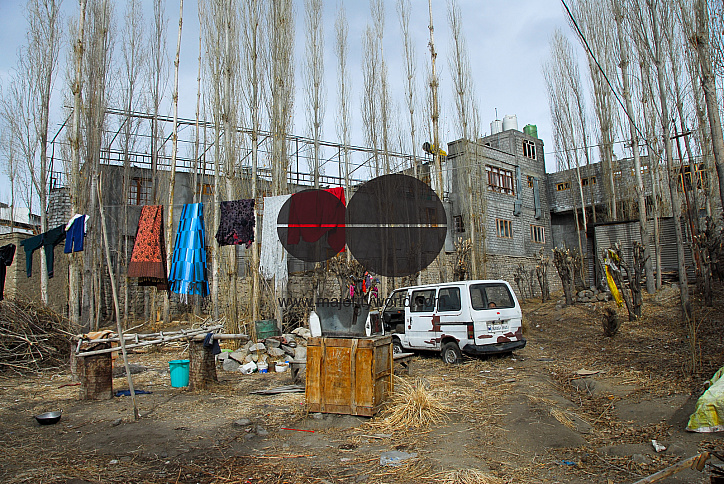 A backyard in Leh, Ladakh where clothes are hung to dry, water is stored and firewood is kept ready.