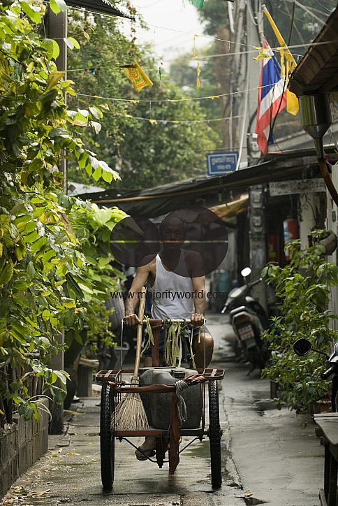 Thailand. Riding down a narrow alley in Bangkok.