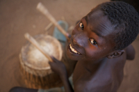  A young boy plays drum during a community dance
