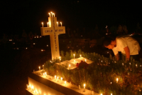 An Indian girl puts candle on a grave on the occasion of All Soul day in Kolkata