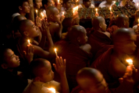 Buddhists celebrating Prabarana Purnima with lighing lamps
