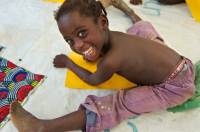  Sitting on the floor, a young Ivorian girl child