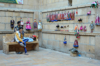  Locals look at traditional looking dolls that are for sale on the street side in Jaisalmer.