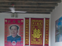 CHINA Elderly man with Mao poster on wall in a traditional Hakka house in a village  in Fujian province.