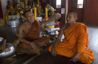 Thailand. Monks seated at their temple in Samut Songkhram.
