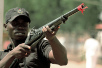 A member of Banga poses with a local gun, which is used within the city of Jimeta-Yola. The red clot
