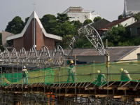 Migrant workers at a construction site by a highway in Singapore