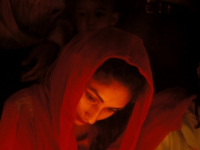 A woman lights candles on the occasion of Budha Purnima