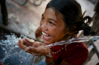 A girl laughs playfully laughs while drinking water